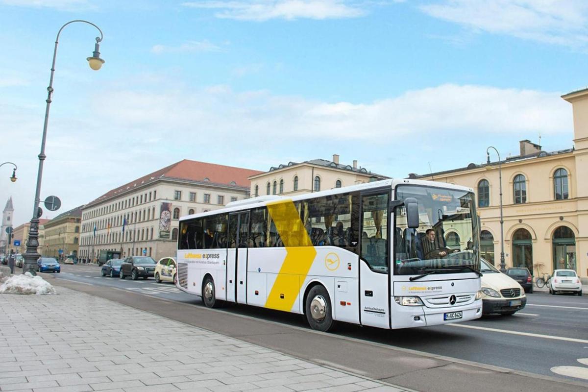 a yellow and white bus driving down a city street