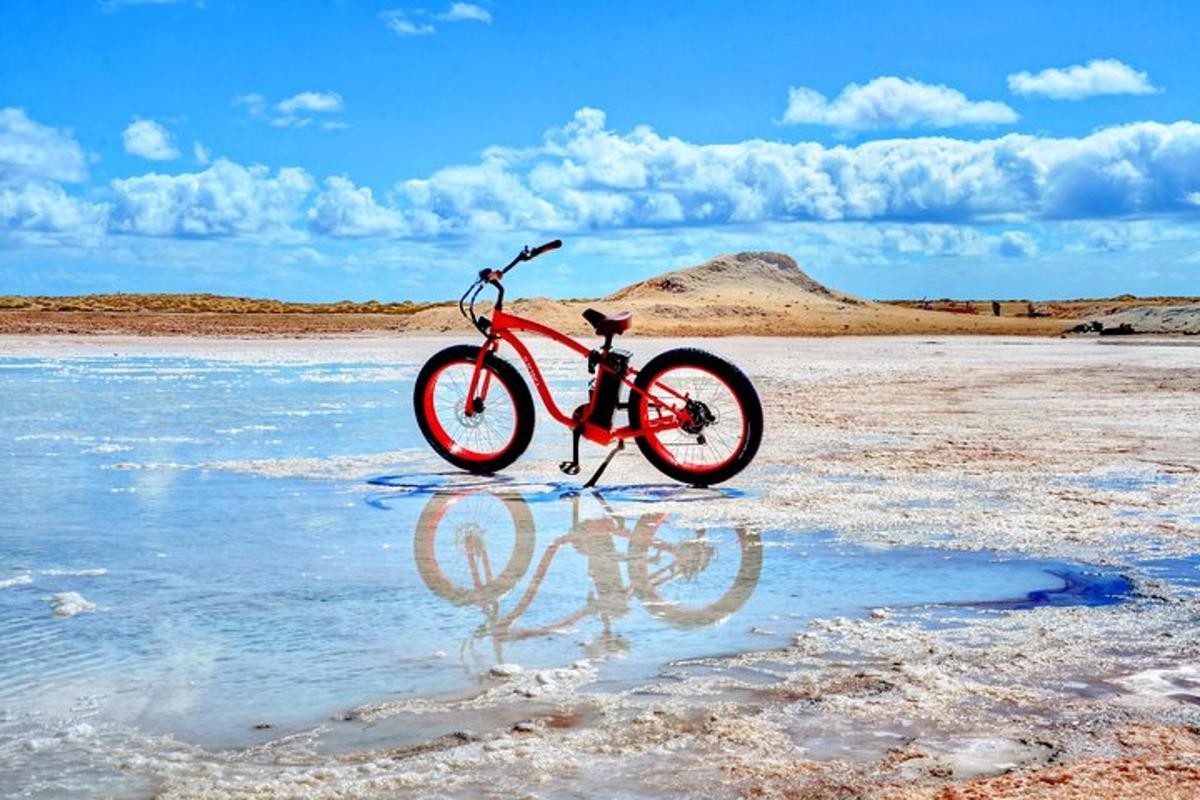 a red bike is sitting on a beach