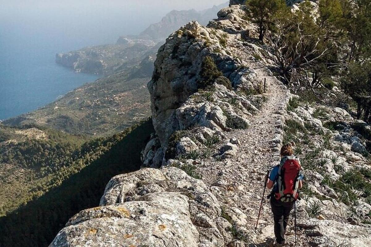 una persona che sale su una montagna rocciosa con uno zaino