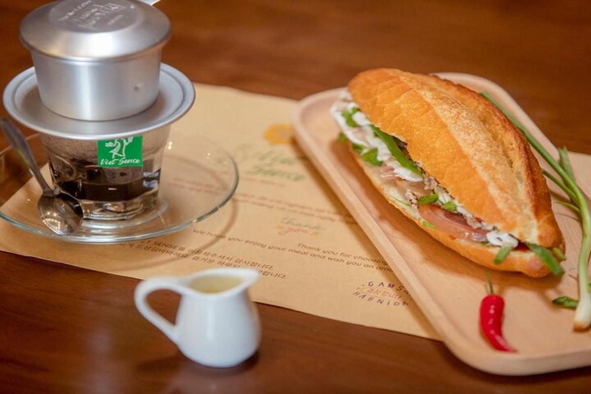 a sandwich sitting on top of a table next to a cup of coffee