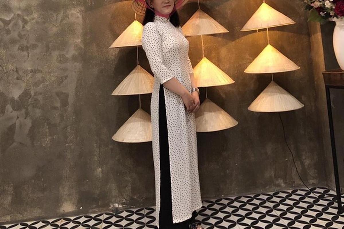 a woman in a dress standing in front of a wall