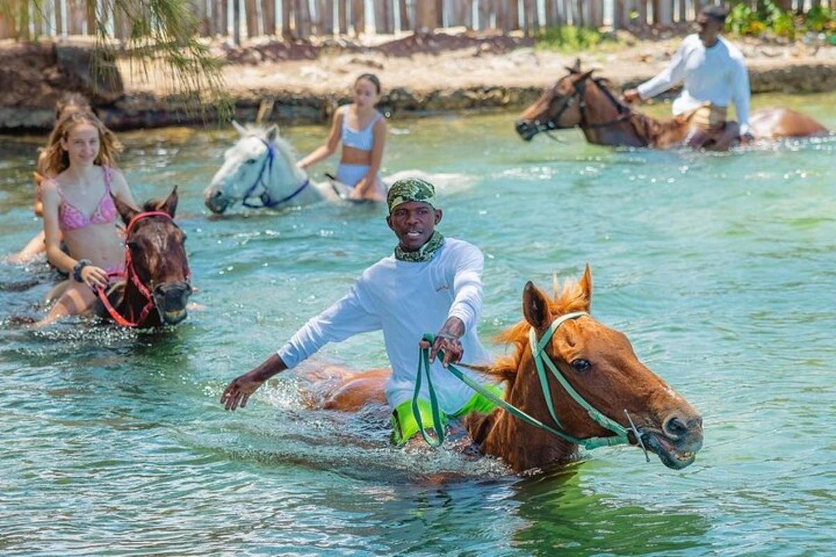 a man riding a horse in the water with people