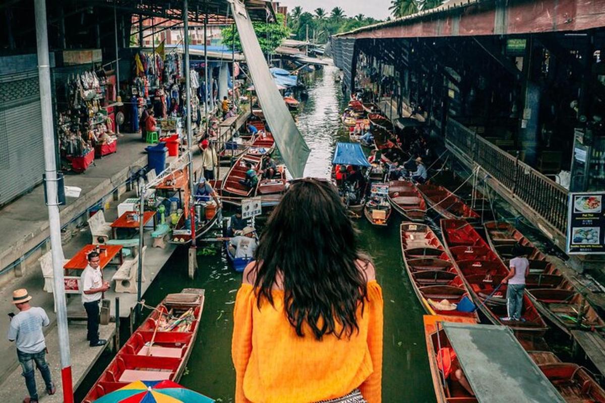 a woman is looking down at boats in a river