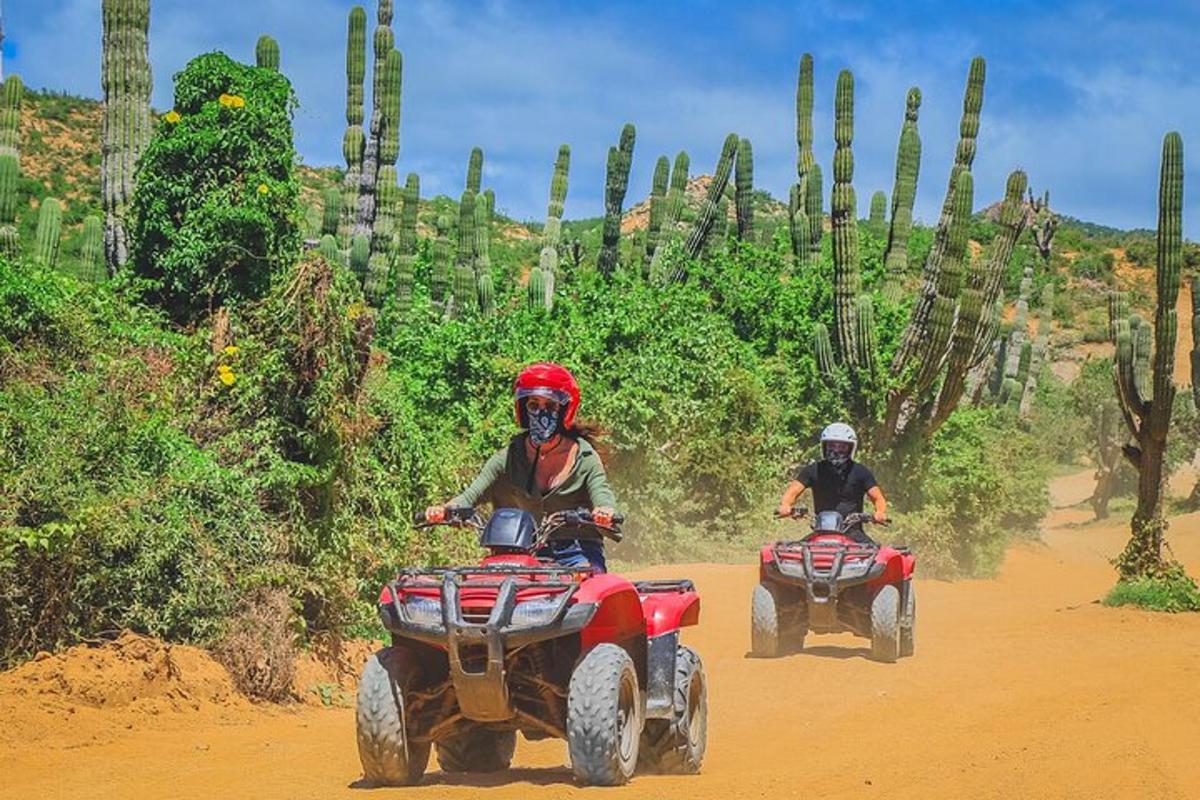 Dos personas viajando en vehículos todo terreno por un camino de tierra