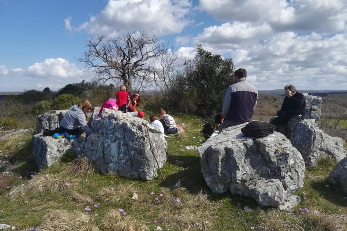 un grup de persones assegudes sobre roques en un camp