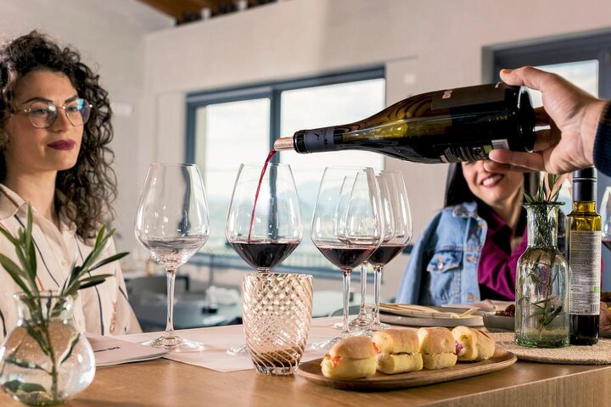 uma mulher derramando uma taça de vinho sobre uma mesa