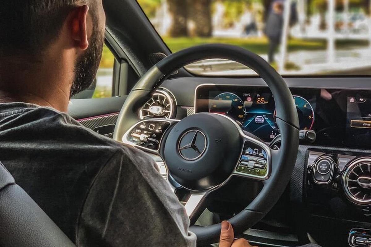muž řídící auto s volantem