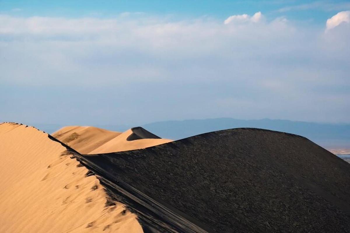 un sacco nero appoggiato sulla cima di una duna di sabbia
