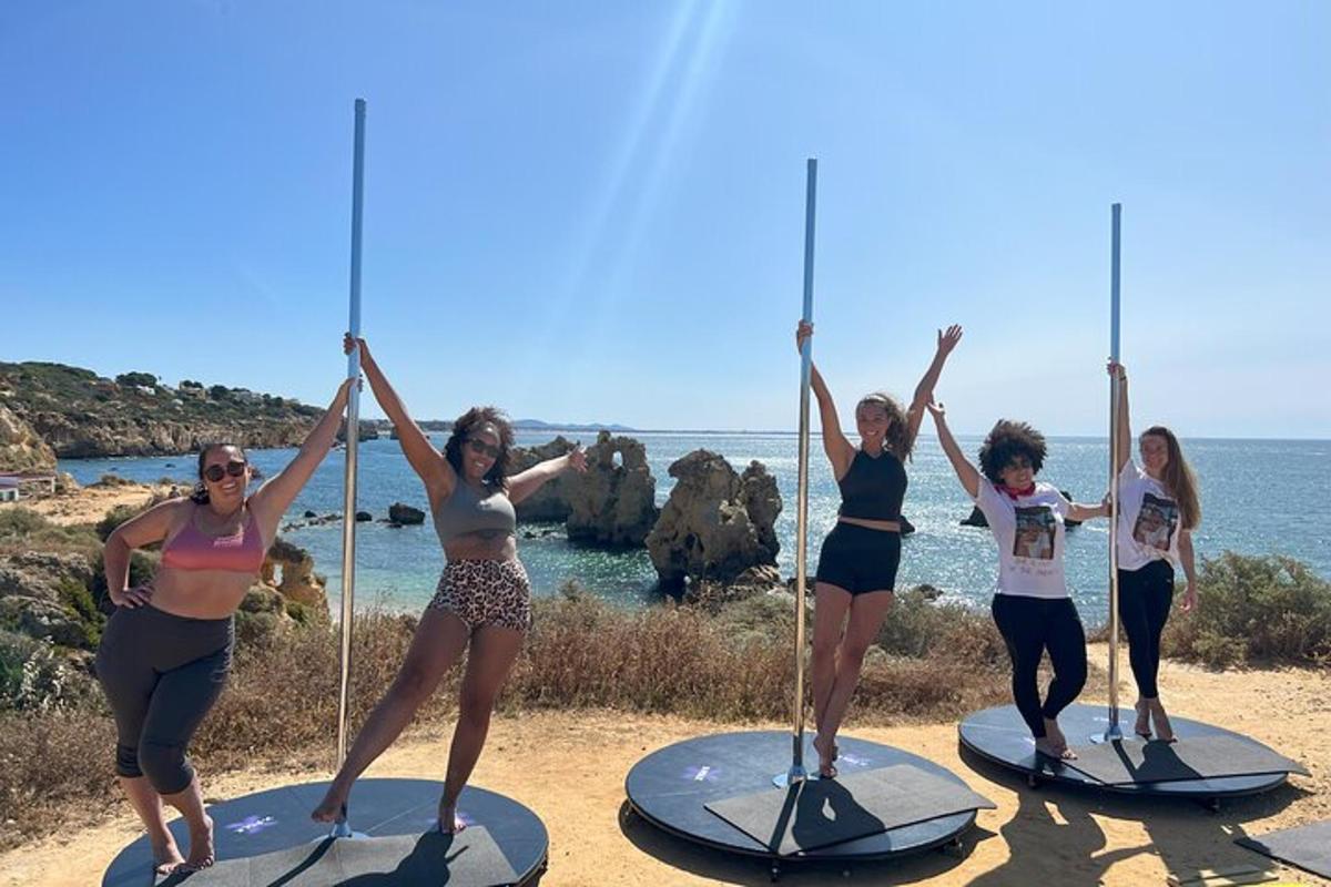 un grup de dones dempeus sobre taules de surf a la platja