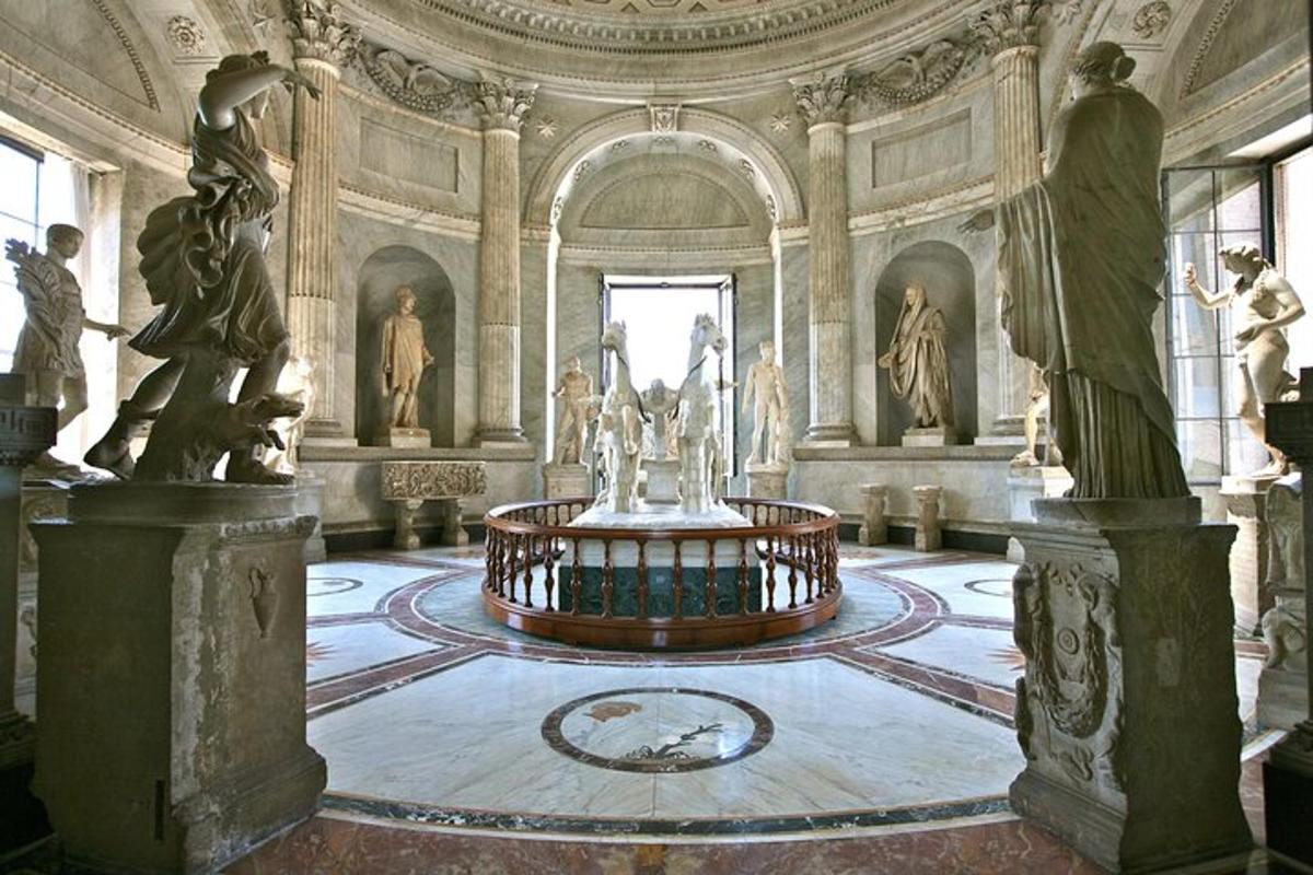 a large room with a fountain in a building with statues
