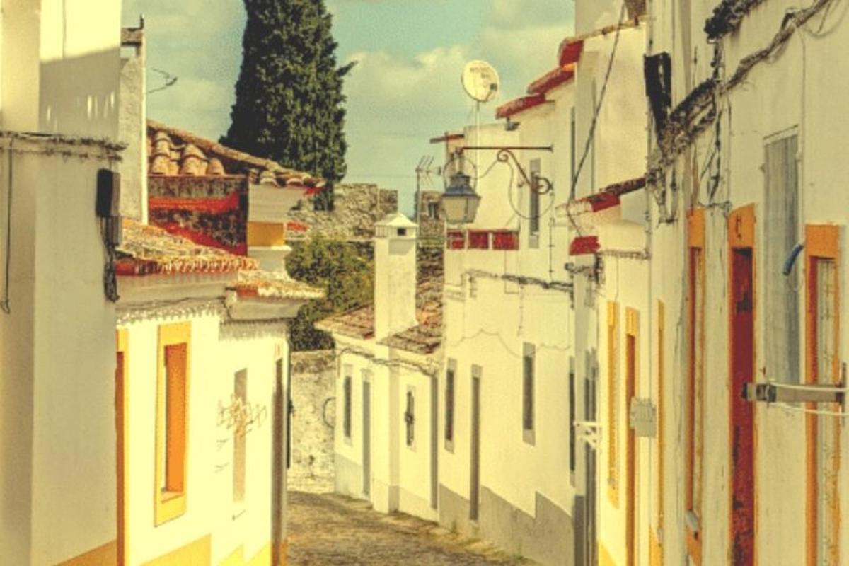 a view of an alley with white buildings
