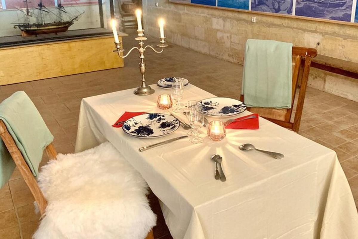 a table with a white table cloth and plates and candles