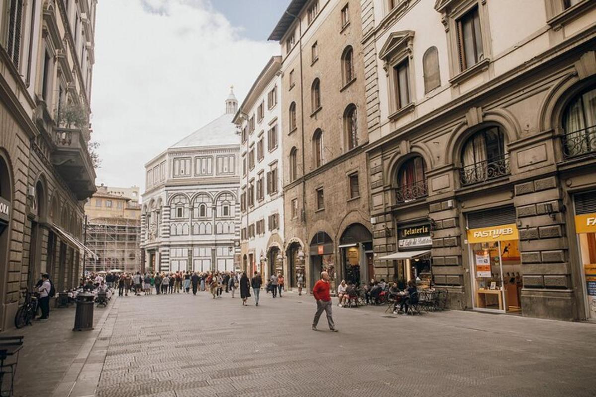 un gruppo di persone che camminano lungo una strada con edifici