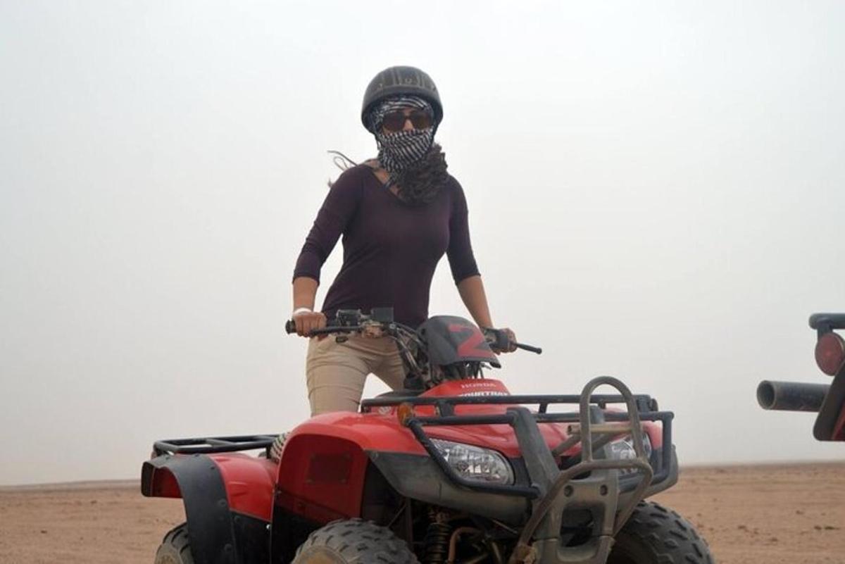 o femeie stând pe un ATV în deșert