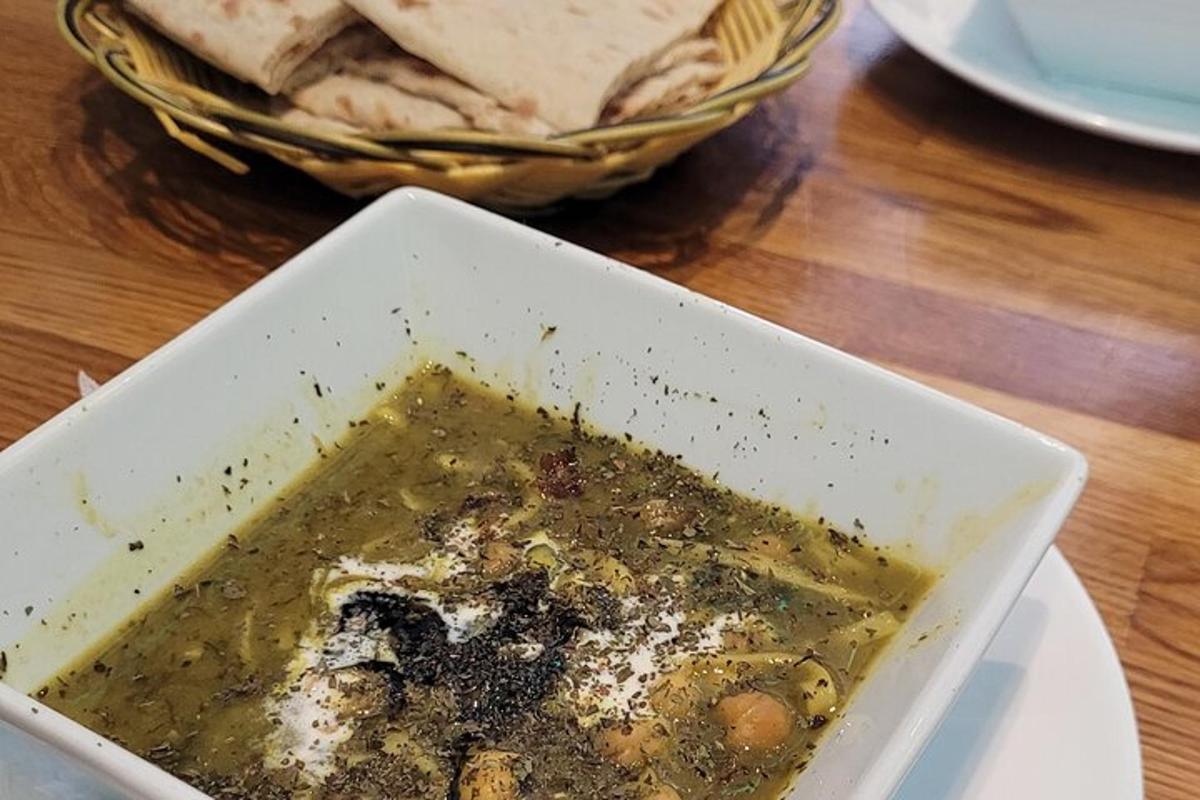 a bowl of soup on a table with a basket of food