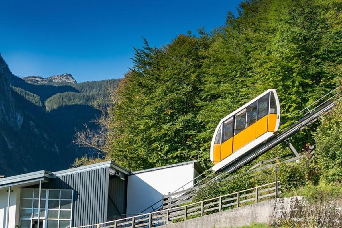 um trem amarelo e branco em uma colina