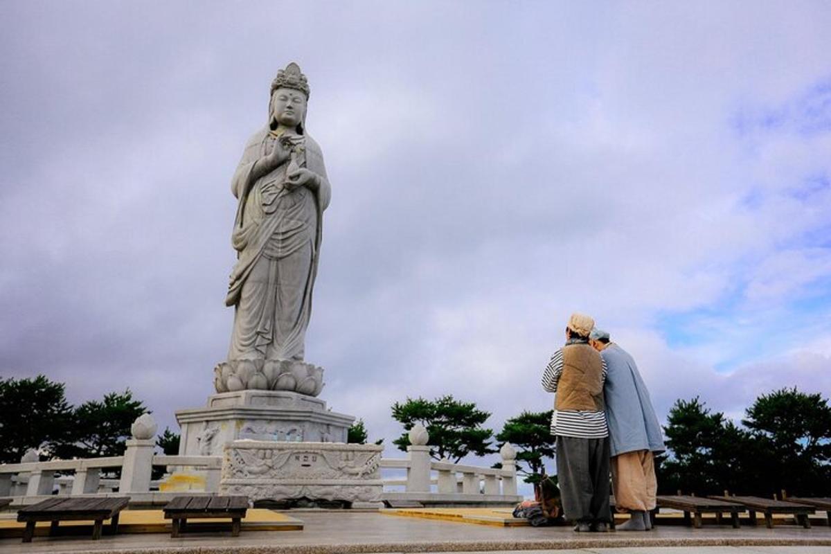 two people standing in front of a statue