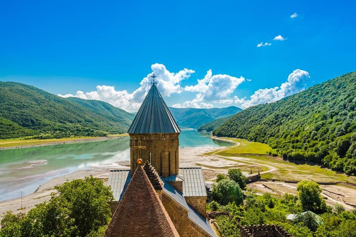 a building next to a river next to a mountain