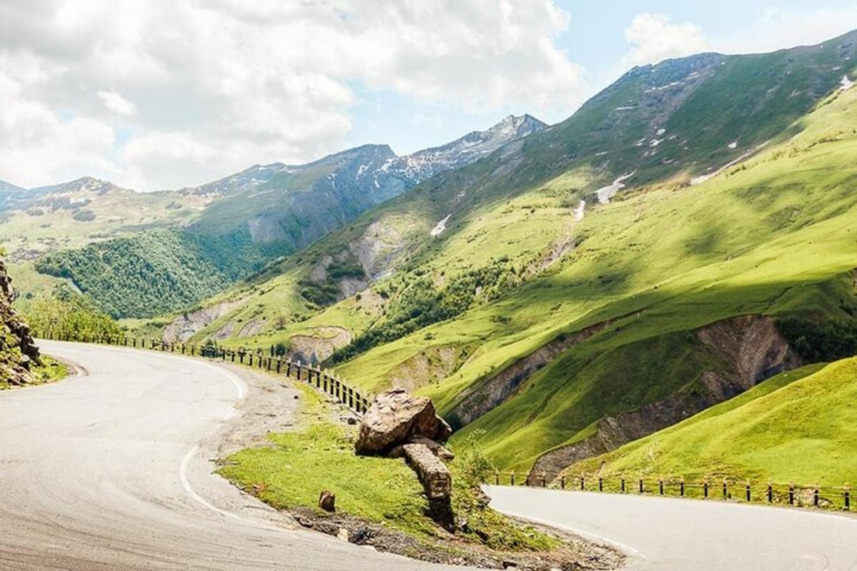 una carretera sinuosa a les muntanyes amb una gran roca