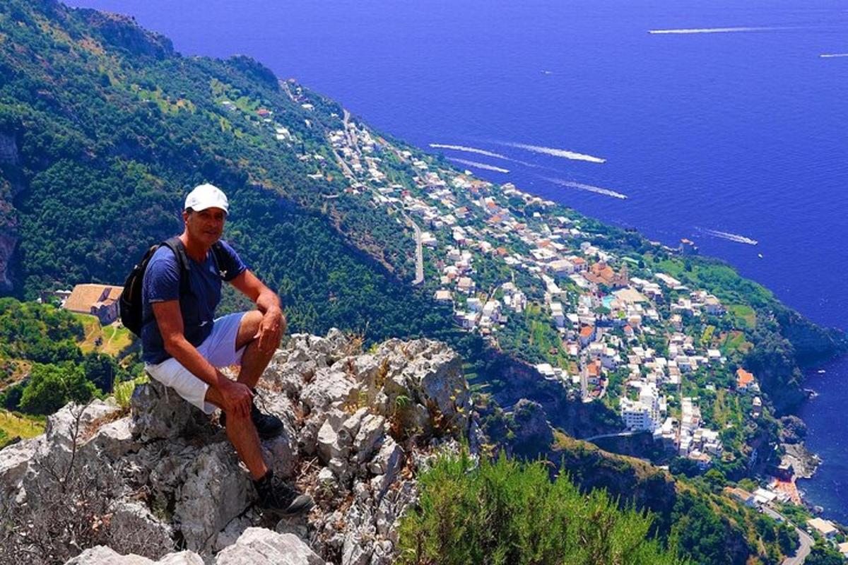 a man sitting on the edge of a mountain
