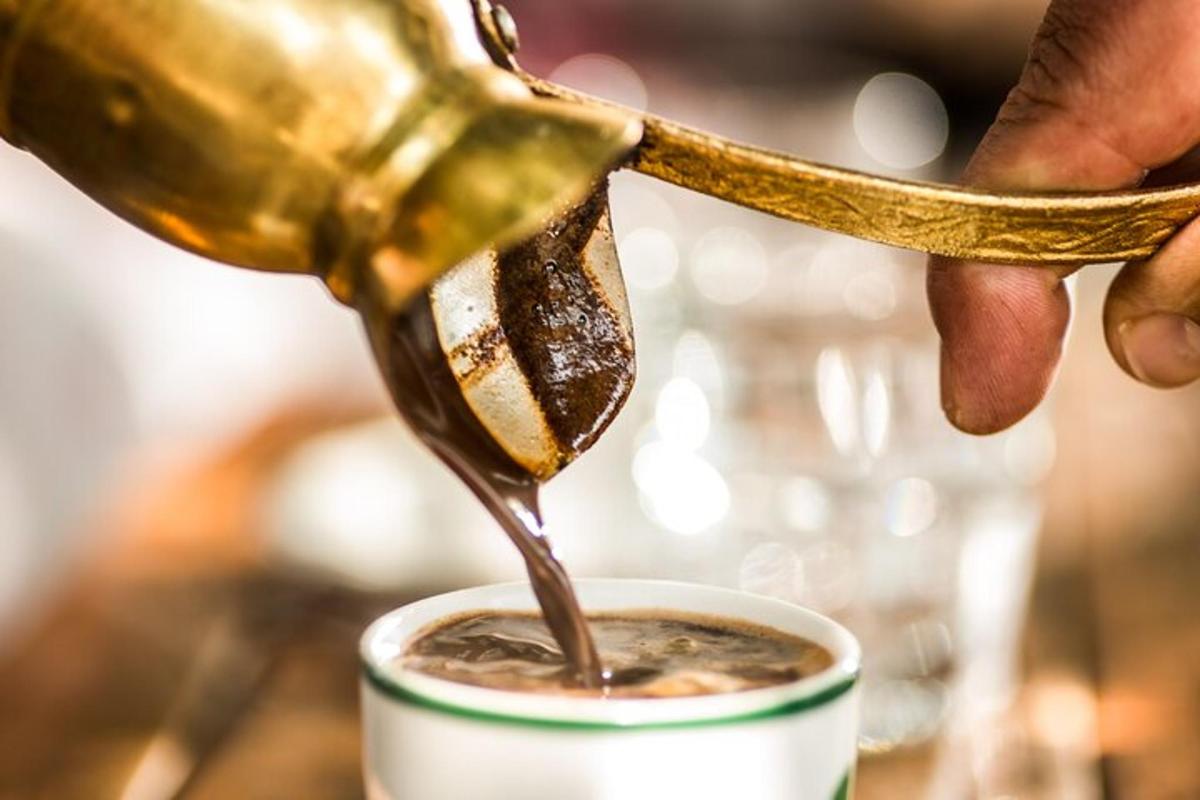 una persona versa del cioccolato in una tazza di caffè