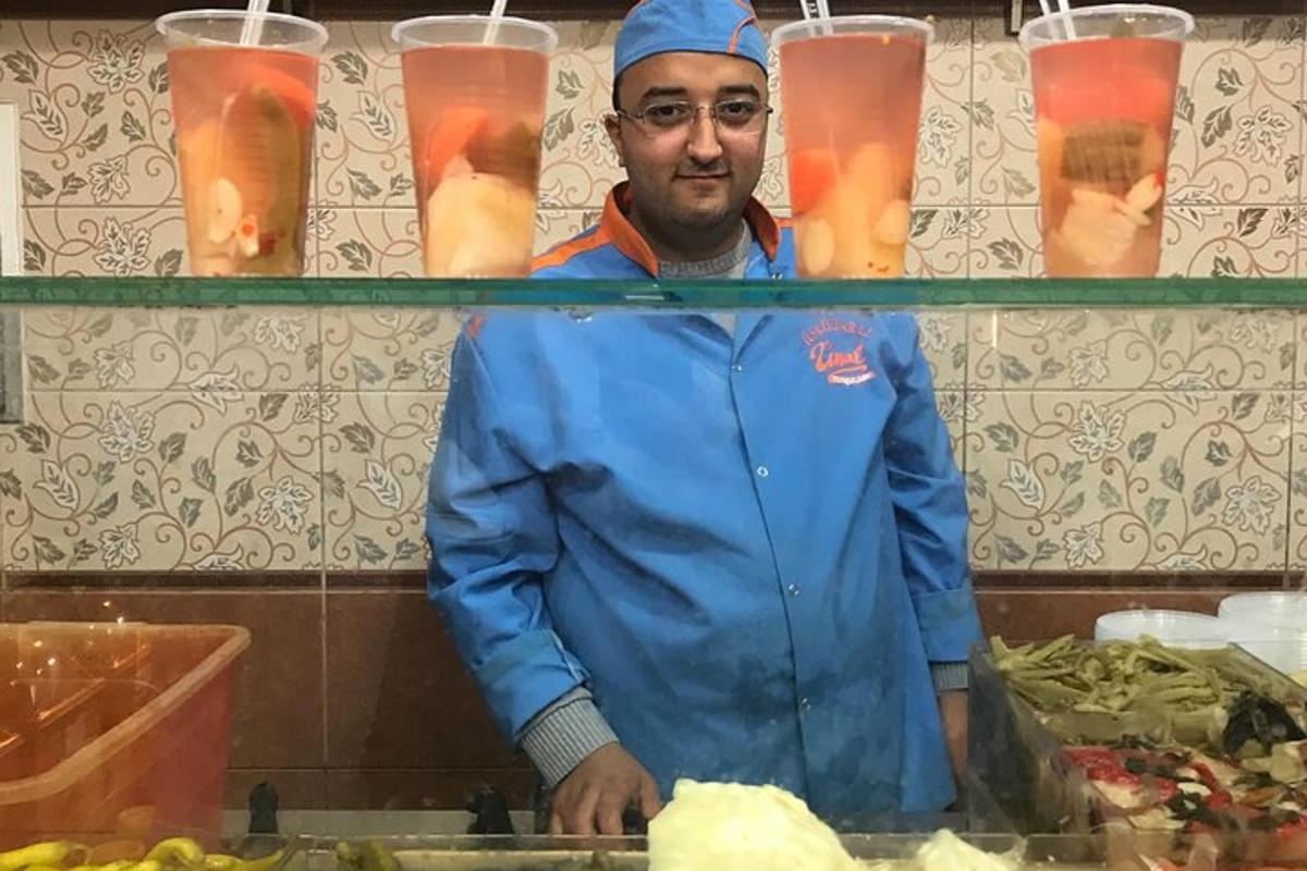 un uomo in piedi dietro un bancone in una cucina