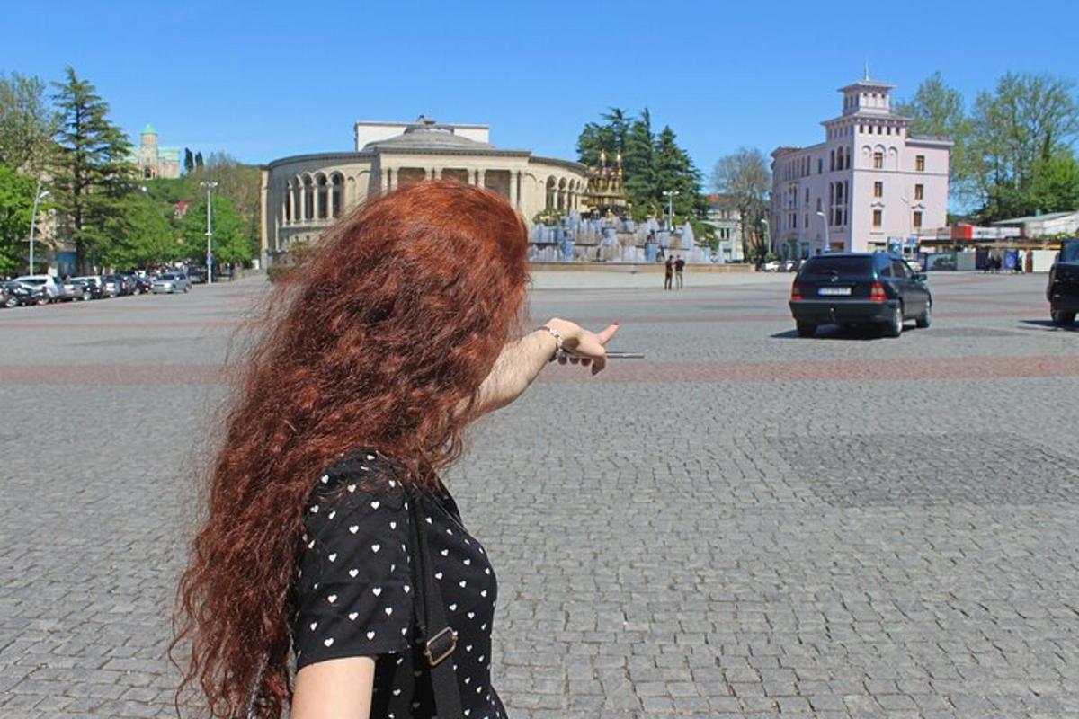 a woman with long red hair pointing at a street