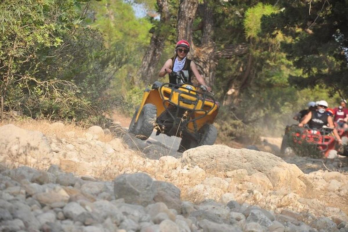 osoba na čtyřkolce na kamenité stezce