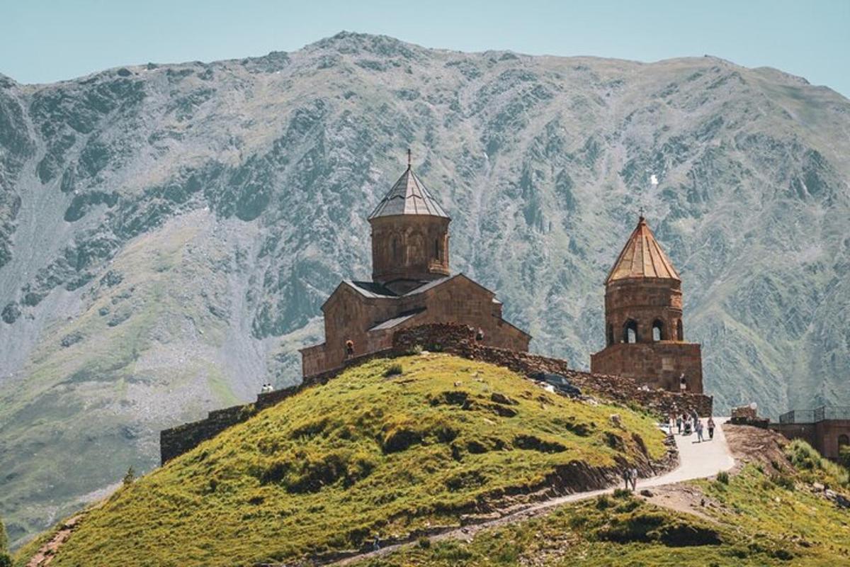 un castello su una collina con le montagne sullo sfondo