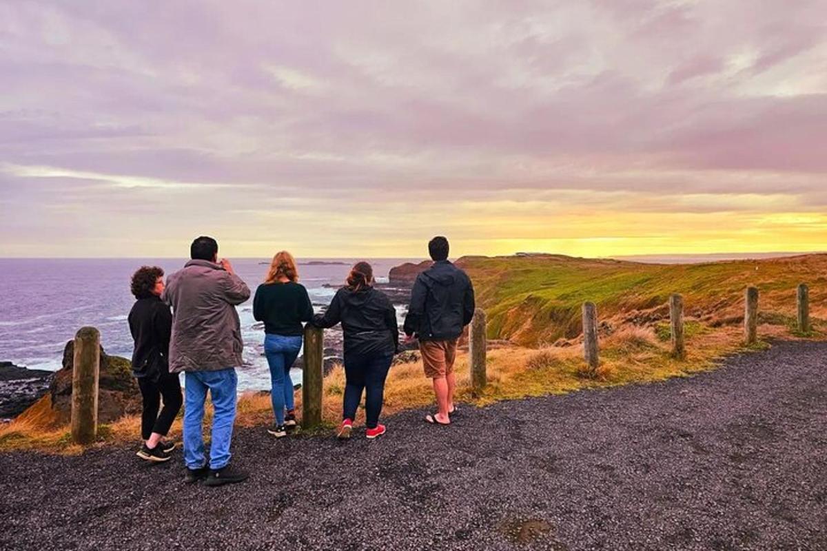 eine Gruppe von Menschen steht auf einer Straße und blickt auf das Meer