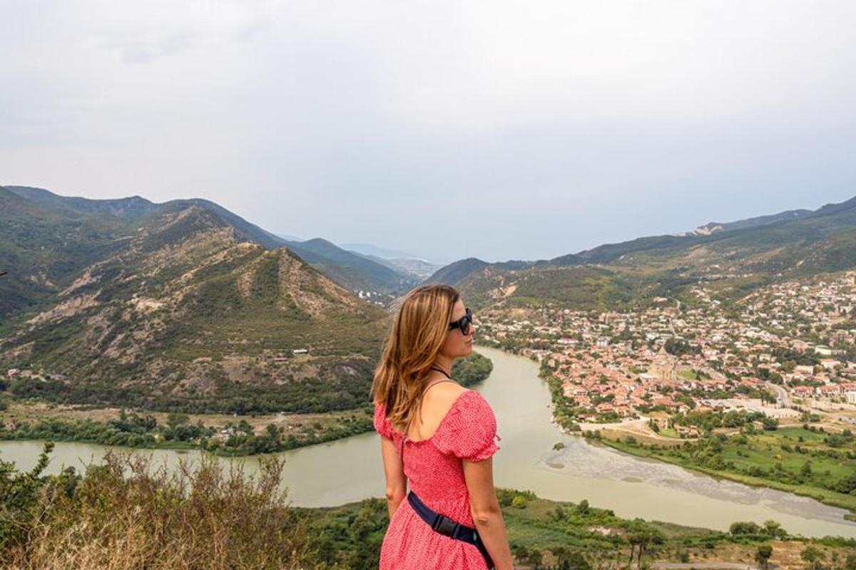 una donna in piedi sulla cima di una collina che domina un fiume