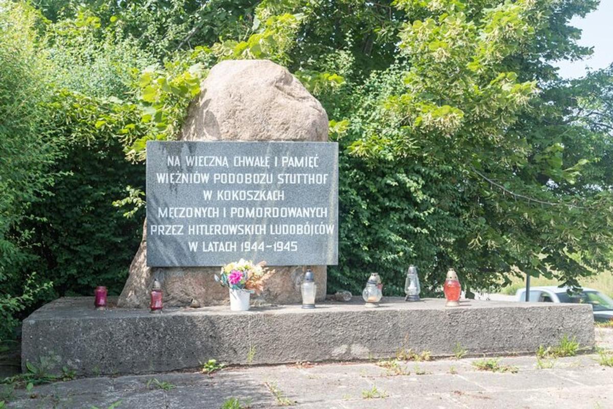 egy emlékmű egy nagy sziklával és néhány virággal