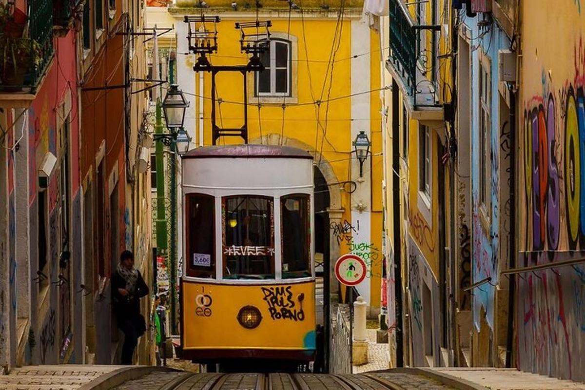 Žlutá tramvaj na městské ulici s graffiti