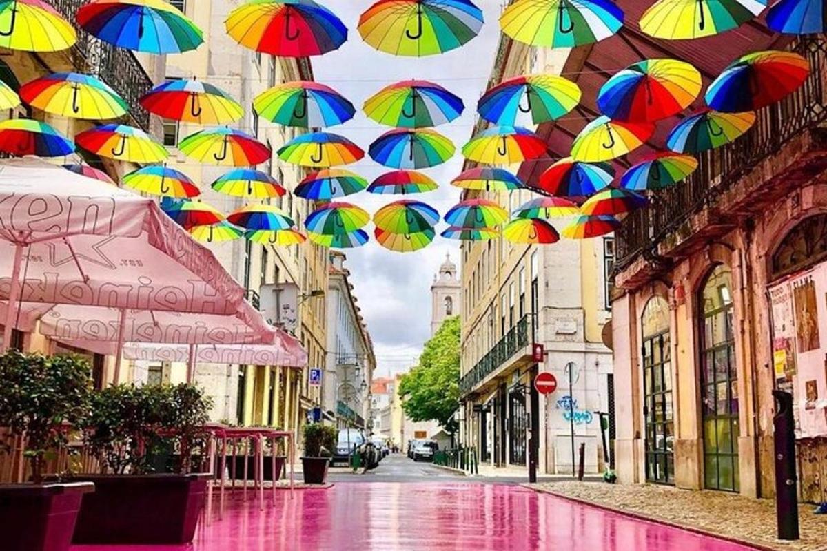 un mazzo di ombrelli colorati appesi su una strada cittadina