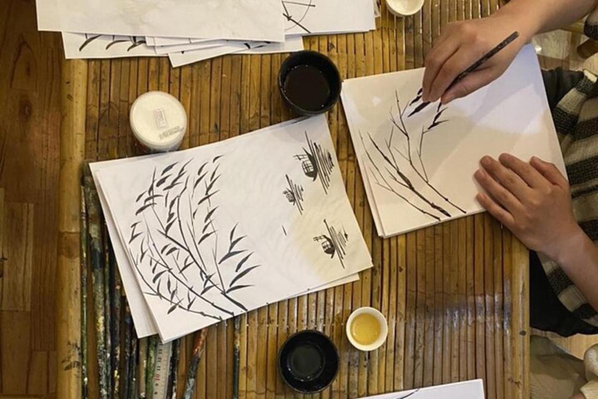 một người đang vẽ hoa trên một tờ giấy trên bàn