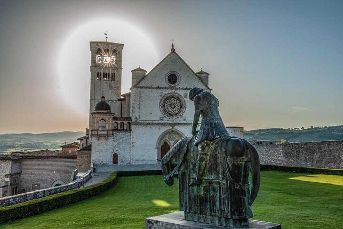 una estatua frente a un edificio con una torre de reloj