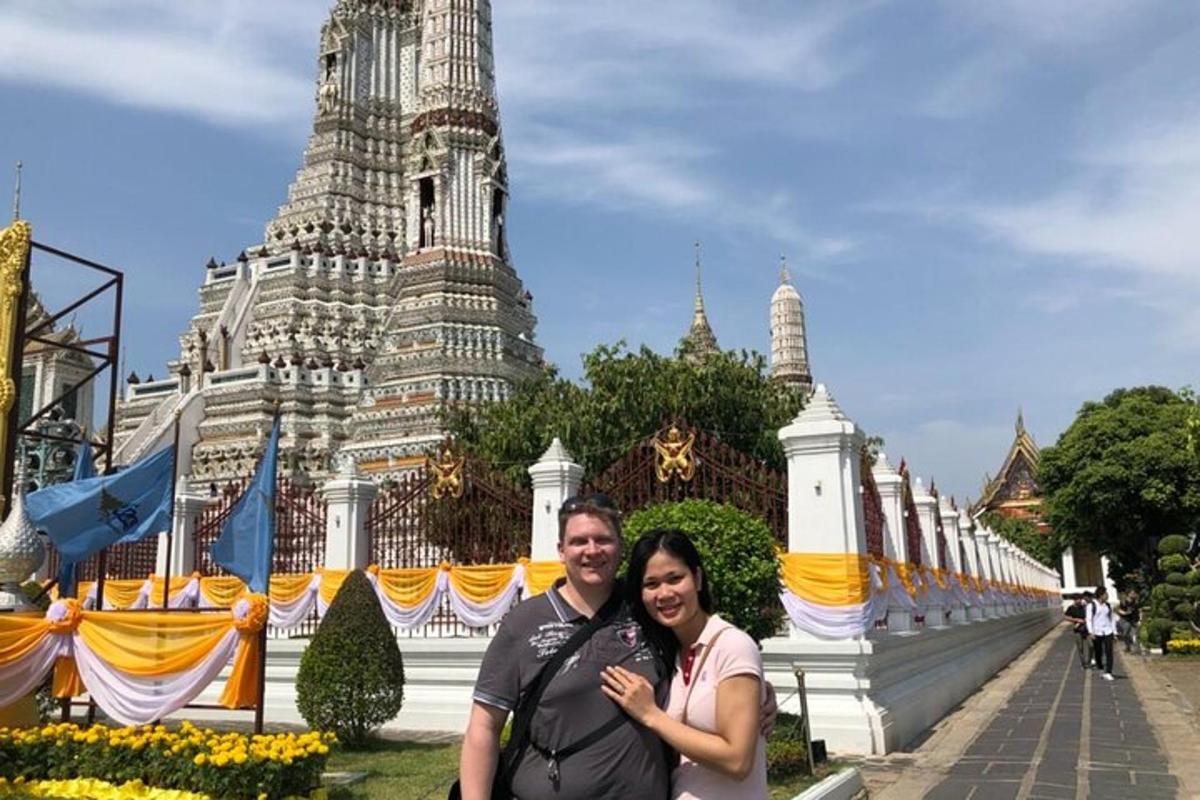 a man and woman posing in front of a building