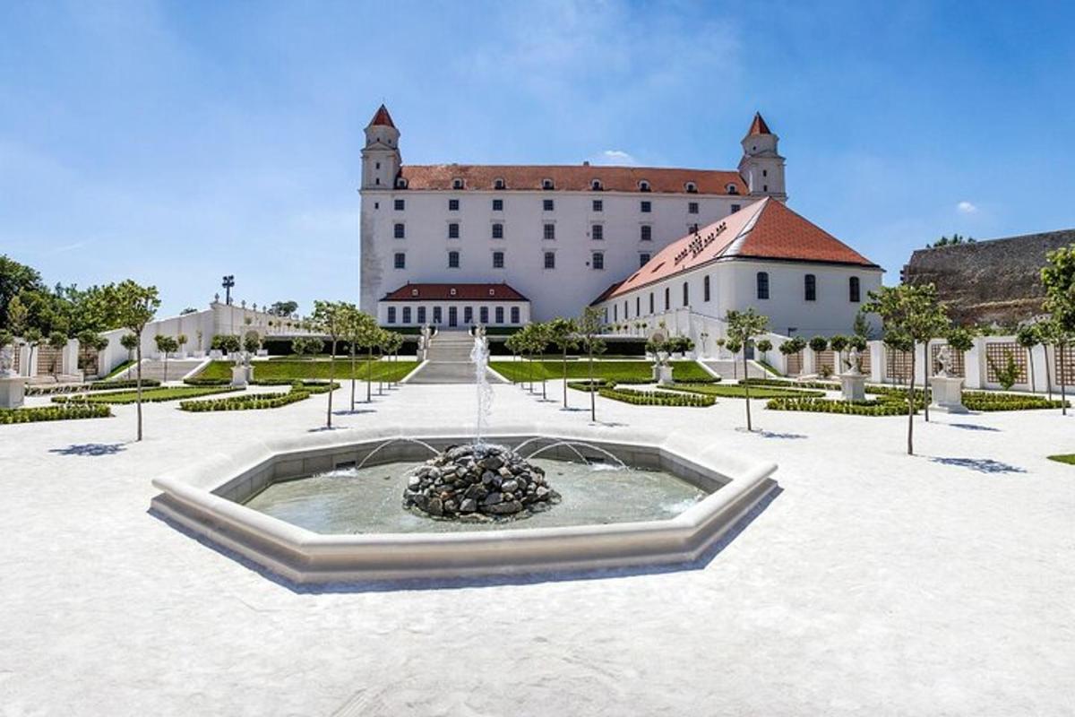 un grande edificio con una fontana al centro di un cortile