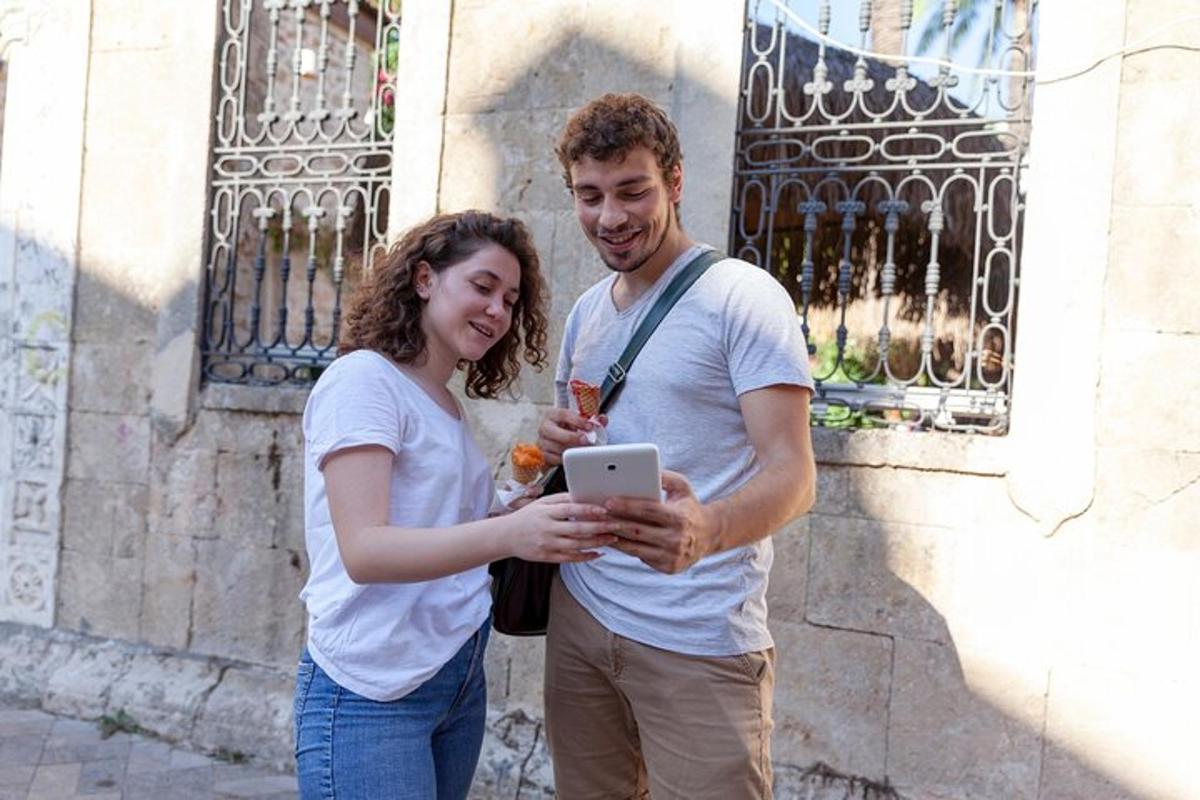 muž a žena stojící vedle budovy s tabletem