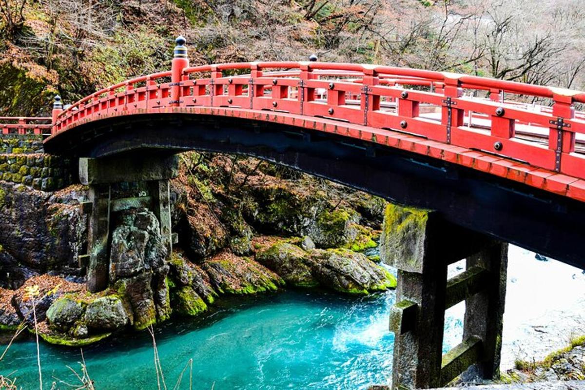 Un puente rojo sobre un río con agua azul.