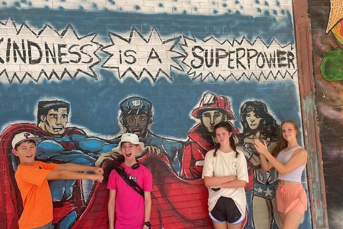 a group of people standing in front of a mural