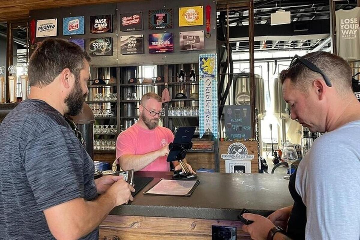 a group of men standing at a counter in a bar