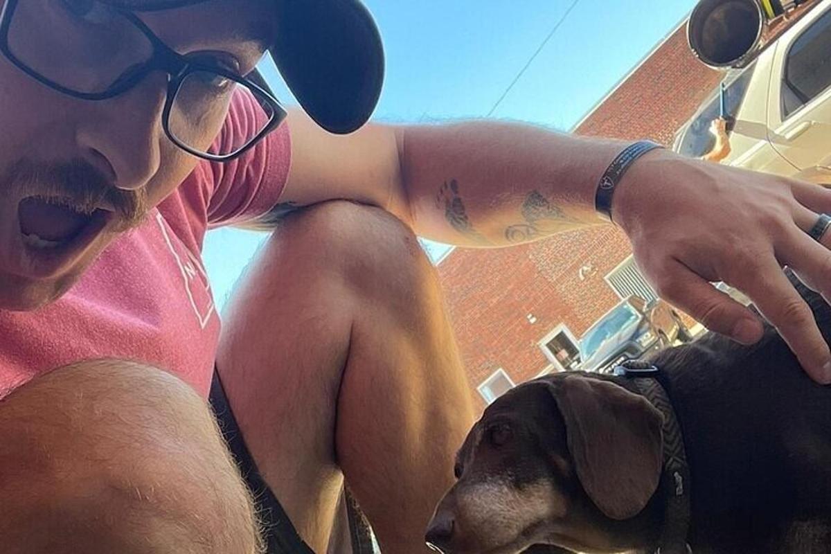 a man is sitting next to a dog