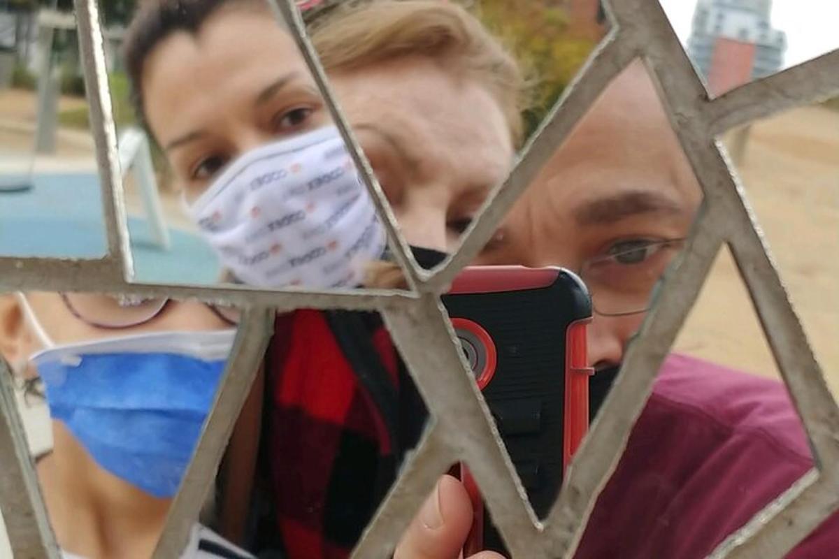 muž fotí dívku s rouškou na obličeji