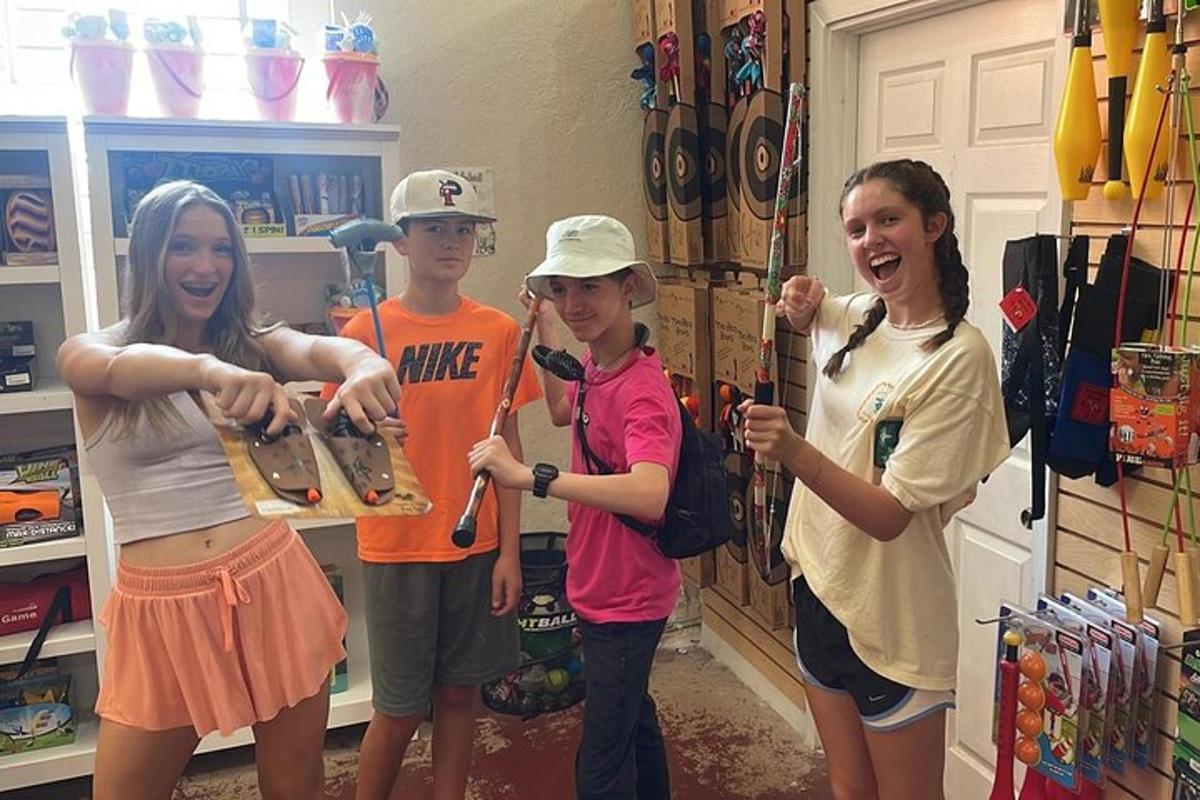 a group of children standing in a room with a skateboard