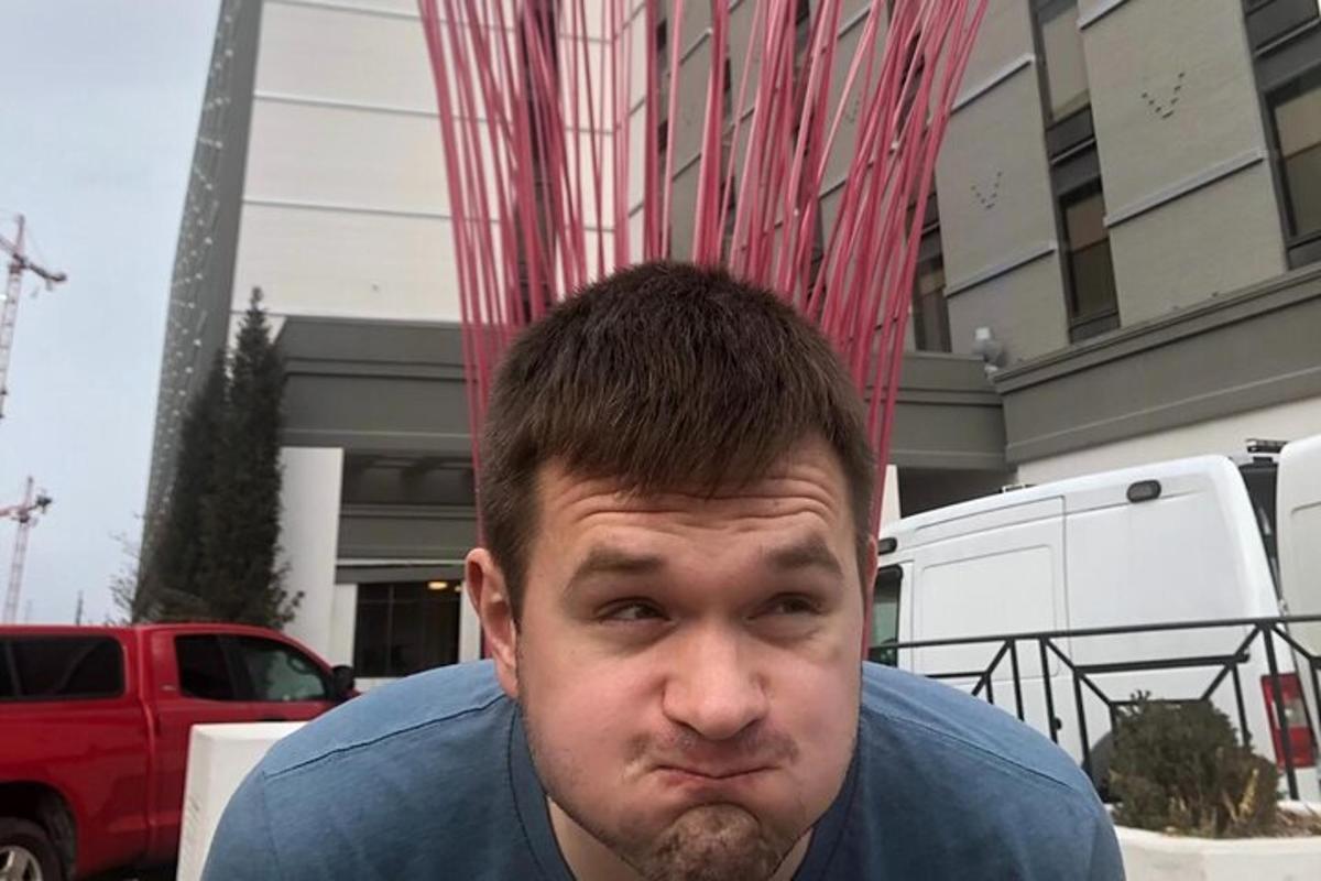 muž stojí před budovou