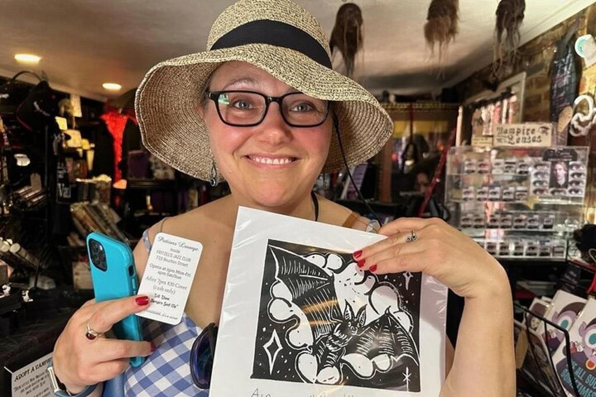 a woman wearing a hat holding up a picture