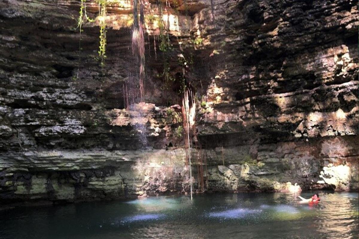 una persona nadando en una cueva con una cascada