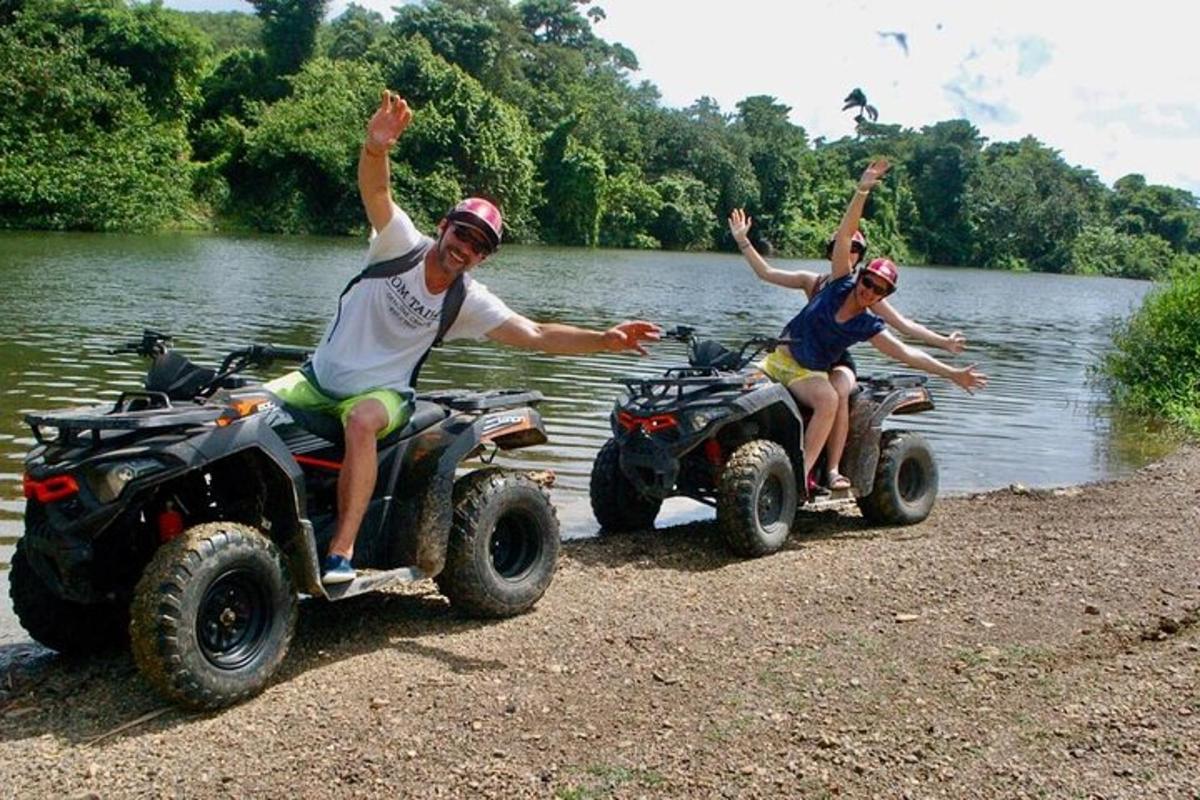 two men are riding atvs in the water