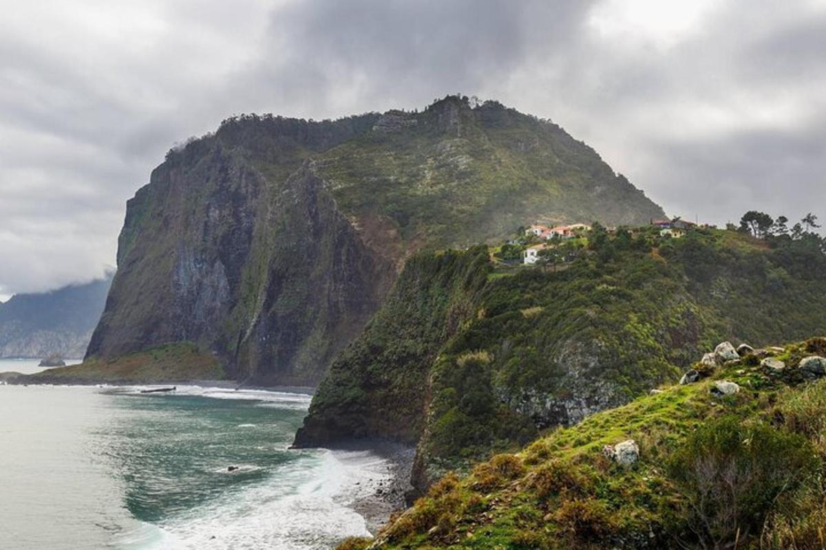 a large mountain next to a body of water